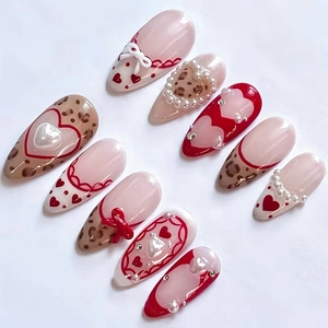 Macro shot of 10pcs handmade press-on nails with red bows, leopard print, and heart pearls