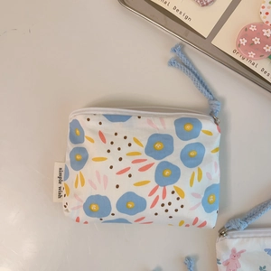 Detail of floral cotton mini pouch with zipper and simple wish label on desk