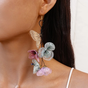Long embroidered butterfly floral fringe earrings worn on model for a vintage aesthetic