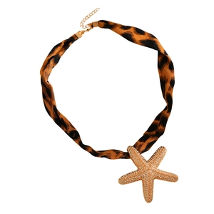 Makroaufnahme einer Leopard-Halskette mit einem großen goldenen Seestern-Anhänger