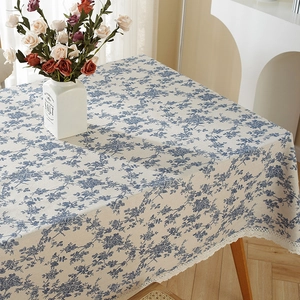 Close-up view of a vintage blue floral cotton linen tablecloth with delicate lace edge