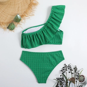 Close-up of vibrant green ruffled one-shoulder bikini with white polka dots and ribbed texture