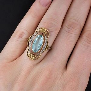 Vintage Victorian floral ring with oval blue gemstone in gold and silver dual-tone finish