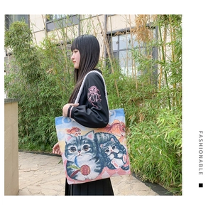 Canvas tote bag with cat and goldfish jacquard patterns shown in a bamboo forest scene