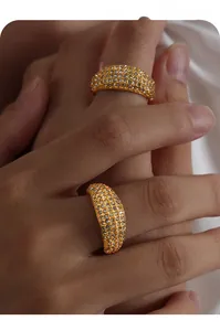 Detail view of wide gold titanium steel rings with full pavé cubic zirconia settings