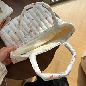 Detailed interior view of white quilted cotton tote with bear and cherry prints