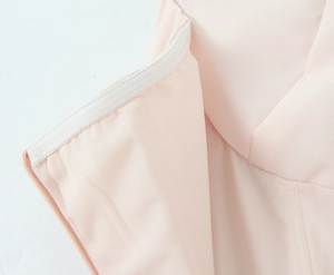 Macro detail of anti-slip silicone strip and stitching on the light pink tube dress