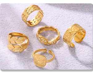 Detailed view of 5 adjustable gold rings with woven and feather textures on plush fabric