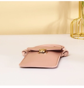 Detailed close-up of pink crossbody phone bag with golden twist lock and thin strap