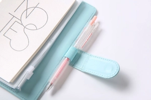 Detail of light blue PU leather notebook cover featuring a functional pen holder loop