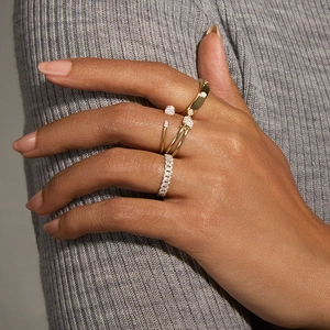 Stackable gold S925 silver twist rings with pavé diamonds worn by a model on hand