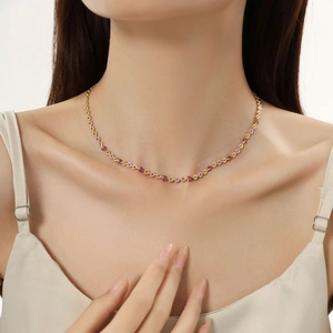 Detail of gold titanium steel necklace with purple enamel hearts on a female model neck
