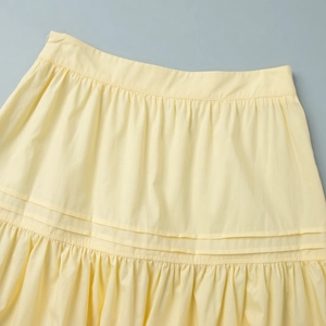 Detail of yellow A-line skirt with pintucks, shirred details and ruffled hemline