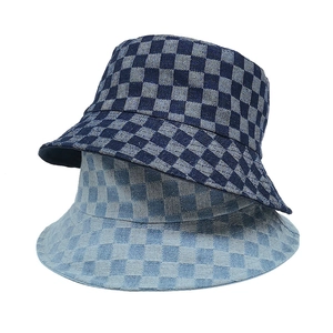Close-up of checkered denim bucket hats in navy and light blue with woven canvas texture