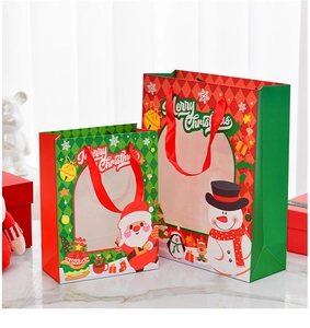 Detail view of red and green Christmas gift bags with transparent windows and ribbon handles