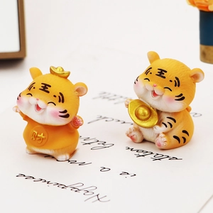 Detail of cute tiger resin figurines with gold ingots for car decor and cake toppers