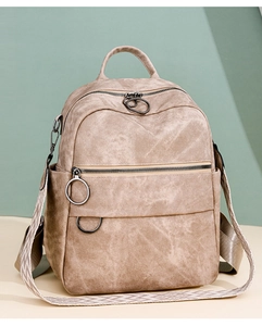 Dettaglio dello zaino da viaggio beige con cerniere in metallo e spallacci