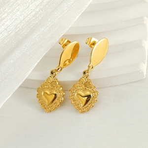 Boucles d'oreilles cœur en or avec motifs vintage gaufrés sur fond de soie blanche