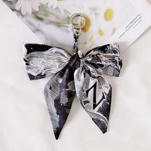 Detail of black and white printed ribbon keychain with silver ring and star patterns
