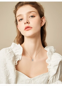 Close-up of a 1 carat round moissanite pendant necklace worn on a model's neck