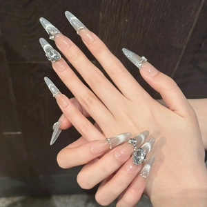 Close-up of silver cat-eye press-on nails with shimmering rhinestones on long stiletto shape