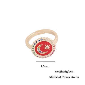 Detail of copper ring featuring red enamel moon star disc with colorful zircons