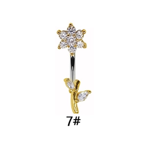 Macro detail of a flower navel ring featuring sparkling zircons and a gold curved bar