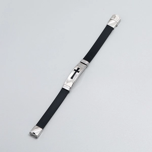 Detail of black silicone bracelet with silver metal plate featuring a cross cutout