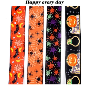 Detail of four Halloween ribbons with spider, bat, and pumpkin patterns in orange and purple