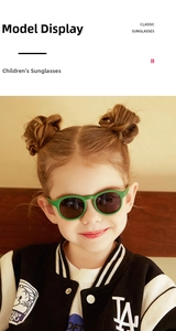 Close-up of green round frame children's silicone sunglasses with dark UV400 lenses