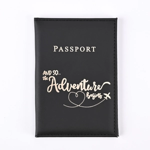 Close-up of black PU leather passport holder with gold foil adventure quote and text