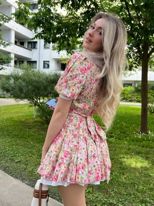 Pink floral mini dress with puff sleeves, lace collar, and layered ruffle hem