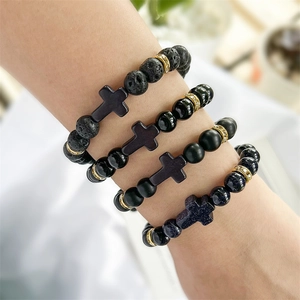 Close-up of four stacked cross bracelets with natural volcanic and blue goldstone beads