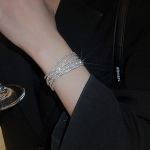 Detail of multi-layered silver bracelet with sparkling zircon stones worn on wrist