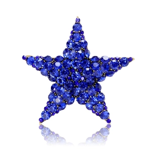 Star-shaped brooch with deep blue crystals and gold alloy base on white background