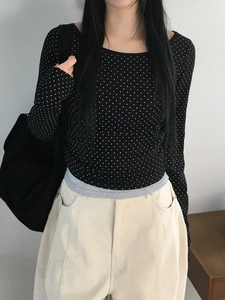 Détail d'un haut noir à manches longues avec pois blancs pour femme porté par mannequin