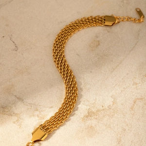 Gros plan d'un bracelet maille dorée avec fermoir mousqueton et chaîne d'extension