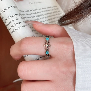 Detailed close-up of a vintage resin open ring with turquoise gems on hand