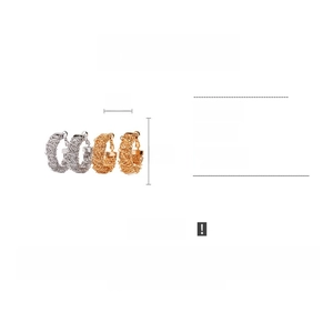 Macro view of metallic braided hoop earrings with detailed copper texture and 24k plating