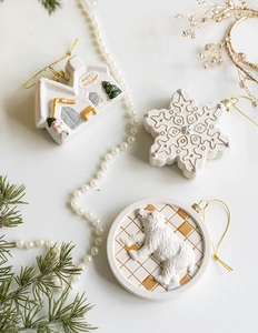 Detailed white resin house and polar bear ornaments with gold accents and pine branches