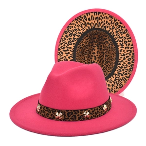Detail of rose red fedora hat featuring leopard print brim lining and gold ornaments