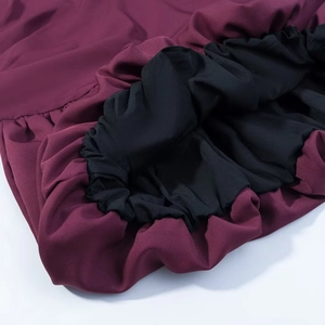 Vue détaillée du tissu bordeaux avec doublure noire et ourlet élastique ajusté