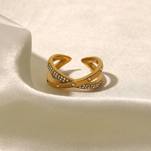 Detailansicht des 18K vergoldeten Crossover-Rings mit Kristallen auf Seidenstoff