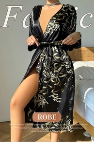 Elegant black satin robe with white floral print and belted waist in home setting