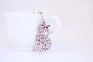Close-up of a cute cat keychain with sparkling pink and clear crystals on silver metal