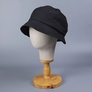 Detail view of the black washed cotton sun hat showing its fine fabric texture on a model head