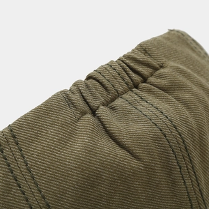 Detail of olive green newsboy cap featuring elastic band and reinforced stitching