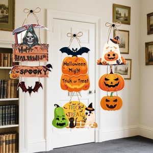 Detail view of three Halloween wooden door hangers with spooky greetings on a white door