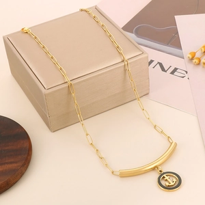 Close-up of gold heart anchor necklace on gift box background with decorative flowers