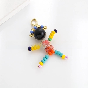 Detail of handmade colorful beaded person charm with golden metal lobster clasp